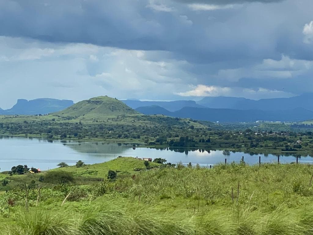 Lake and green hills under dramatic clouds