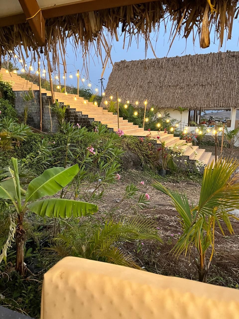 Steps up to a chalet lit with string lights at dusk